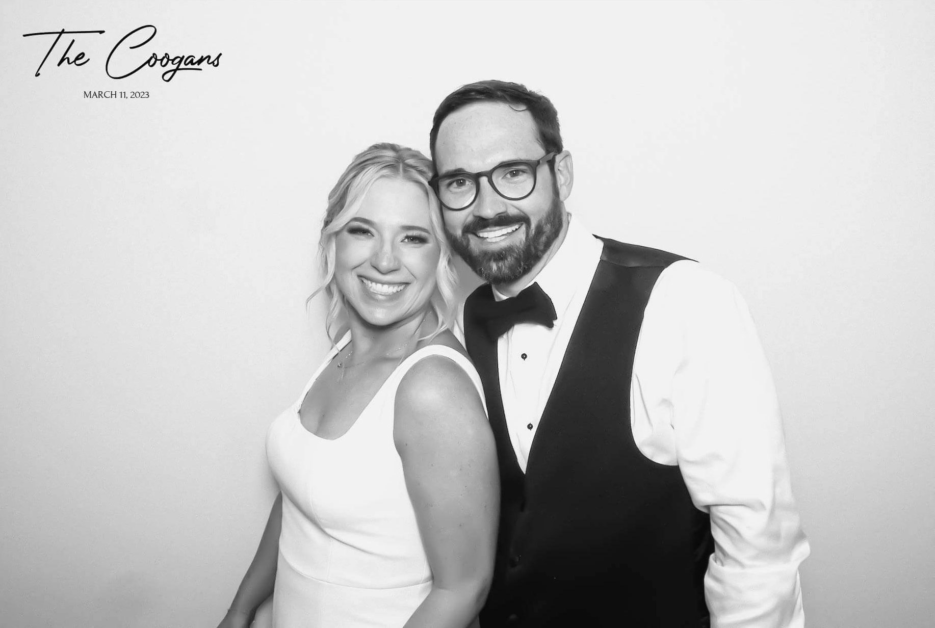 Wedding couple smiling at the camera in black and white.