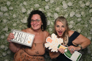 Photo booth hd with guests holding props and signs at a wedding celebration event.