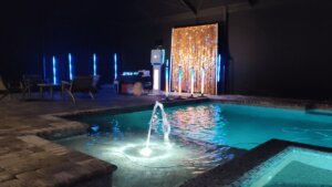 Indoor pool party with photo booth, lighting, and seating for events.
