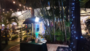 Night garden party photo booth with string lights and lush greenery, perfect for events and celebrat.