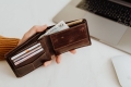 Monthly Budget Planner Template 8 kaboompics closeup man hand open brown genuine leather wallet with banknote and credit cards on marble background with clipping path 15054