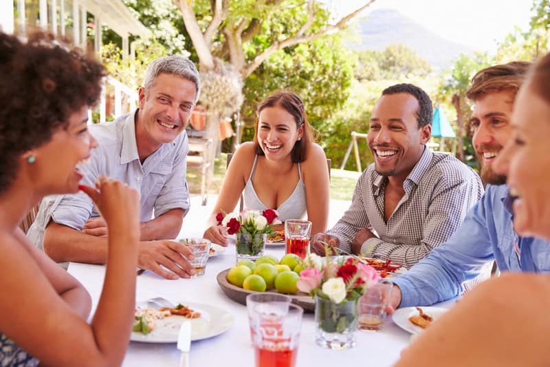 Friends dining together at a table in a garden