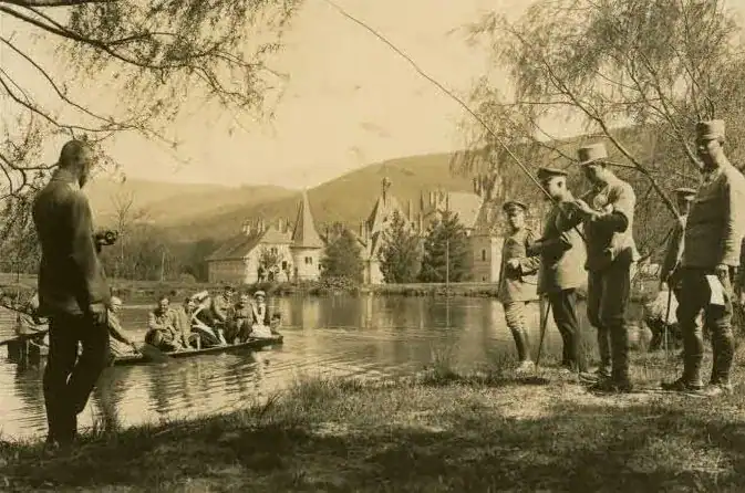 Група людей на березі річки біля Палацу Шенборнів, історична фотографія.