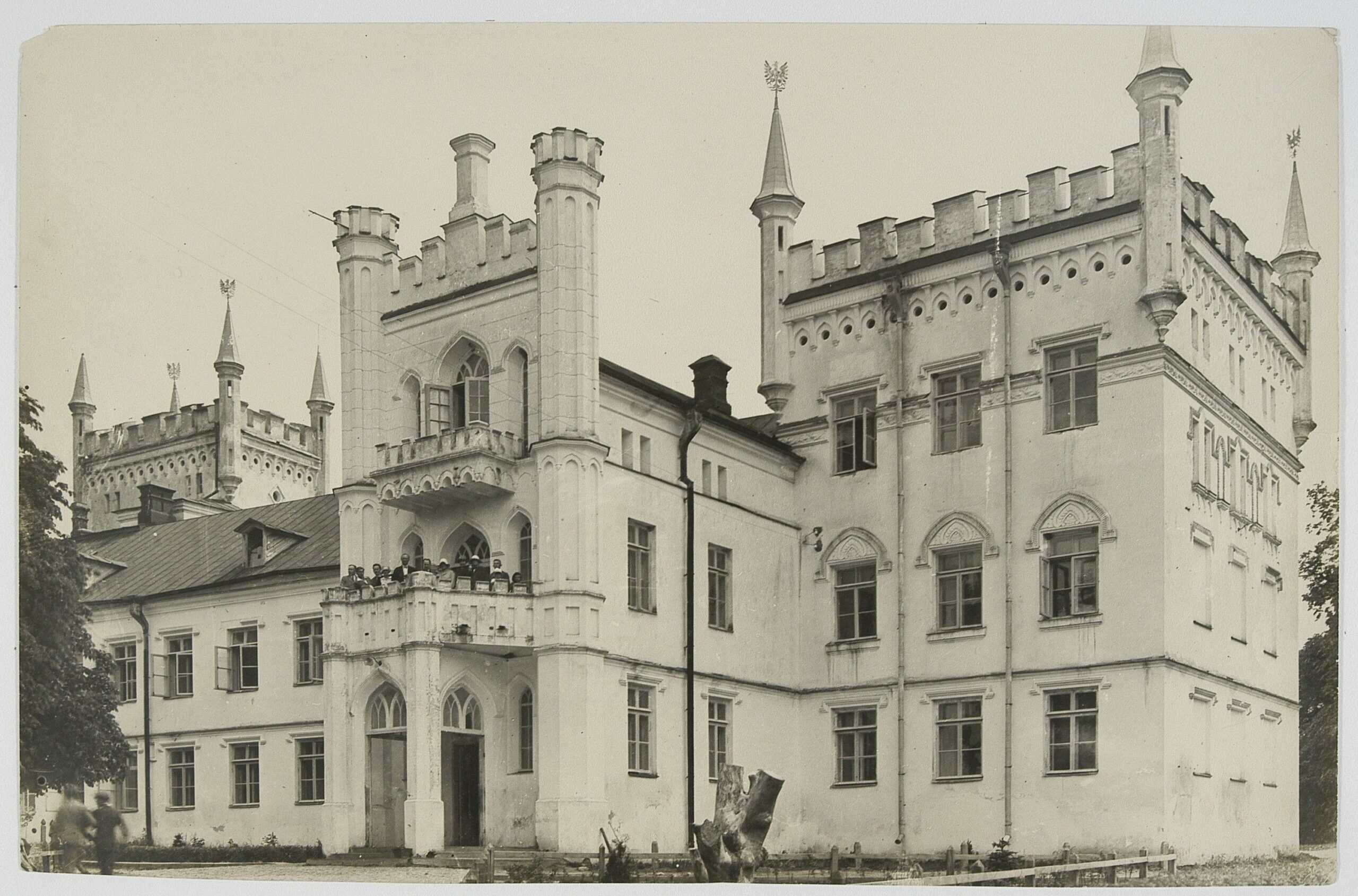 Історична фотографія замку з високими вежами та кам'яними стінами.