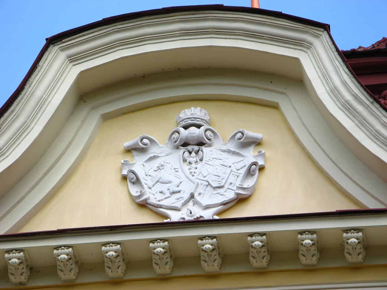 Барельєф із гербом на історичній будівлі в Україні.