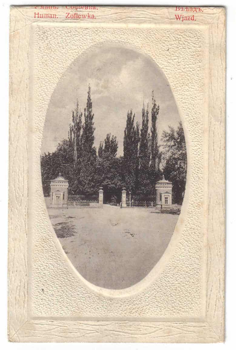 Старовинна фотографія входу до парку з високими деревами та воротами.