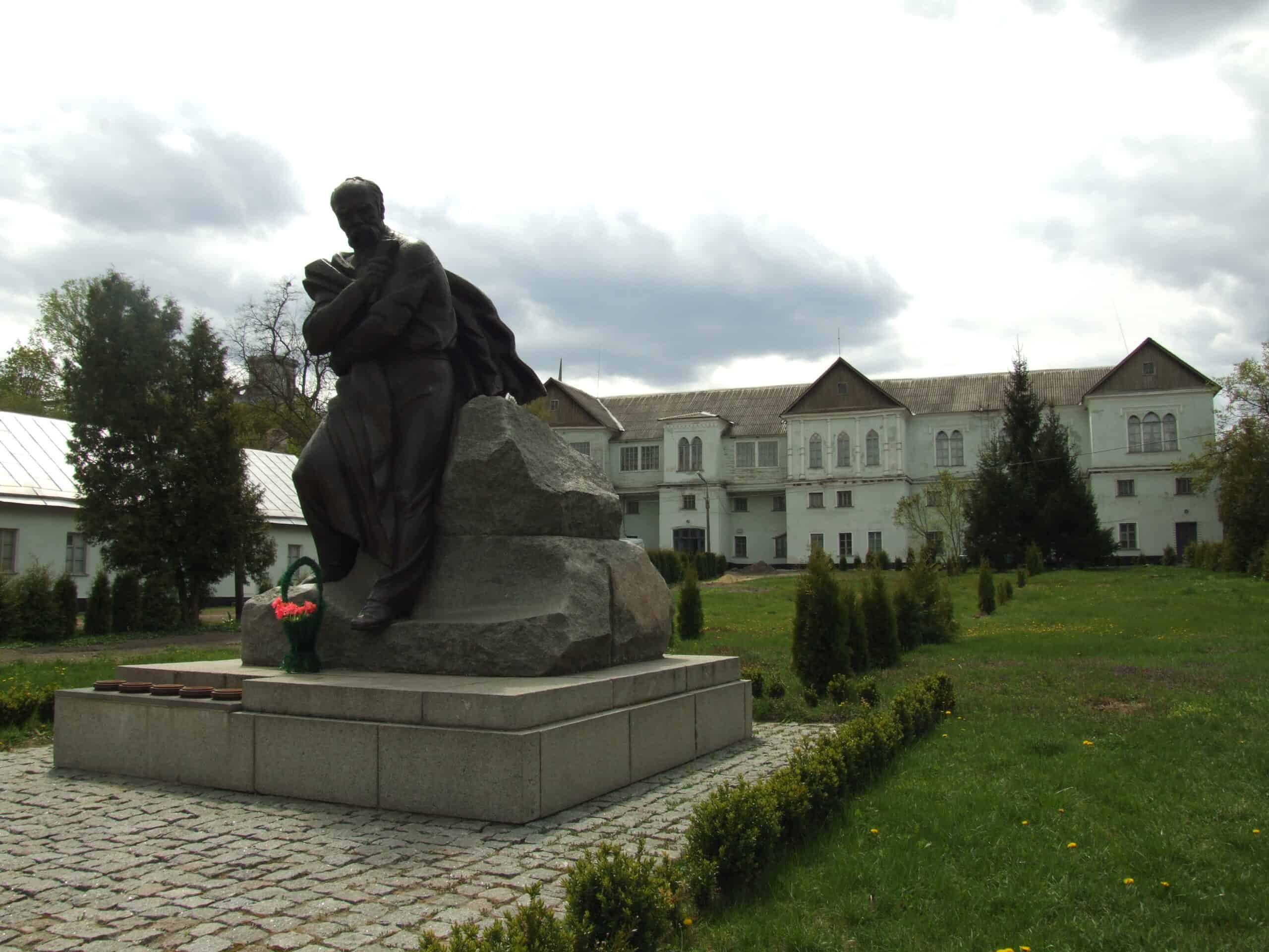 Пам'ятник у Корсуні-Шевченківському з історичним палацом на задньому плані.