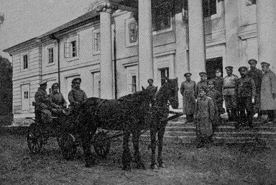 Група людей і коней біля історичної будівлі, старе фото.