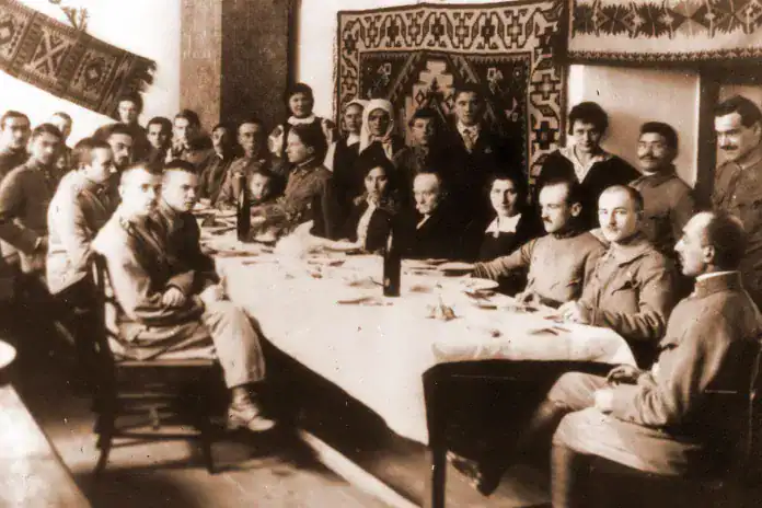 Групова фотографія українських людей у кімнаті з традиційним українським декором.