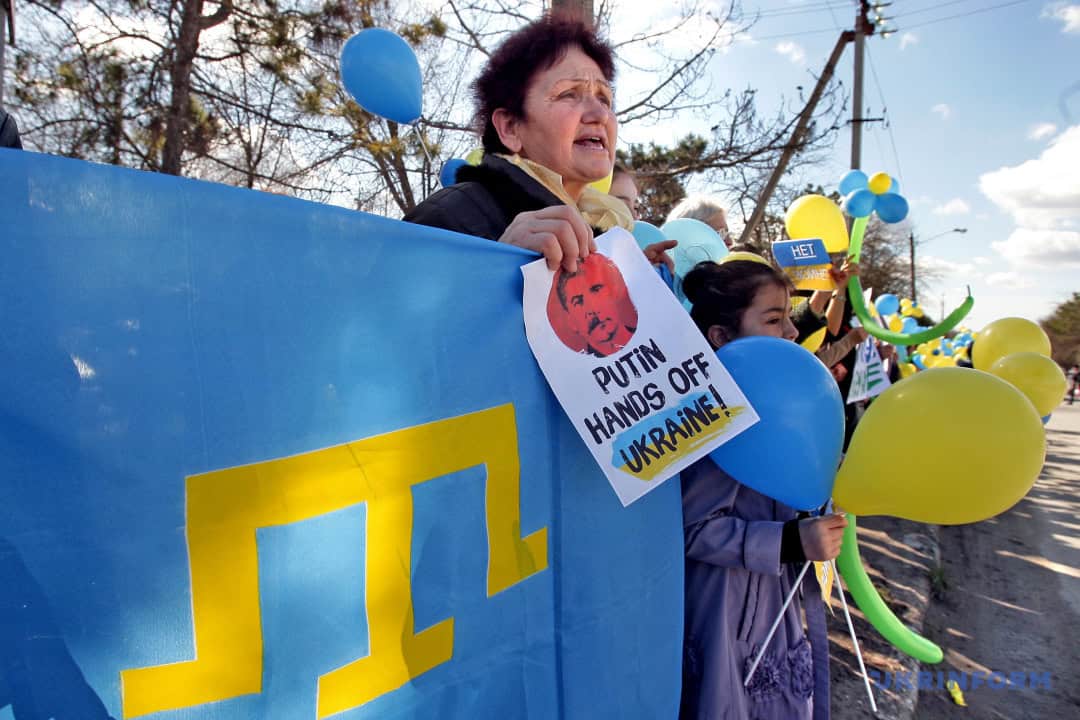 Мітинг проти окупації Криму з плакатом та жовто-блакитними кульками.