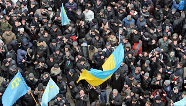Масовий мітинг з українськими прапорами на площі.
