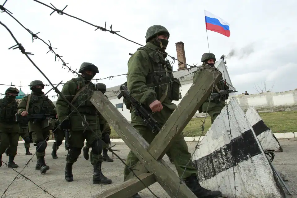 Військові біля огорожі з російським прапором у Криму.