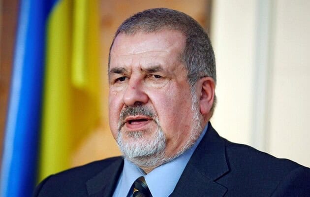 Чоловік у костюмі говорить на публічній події.