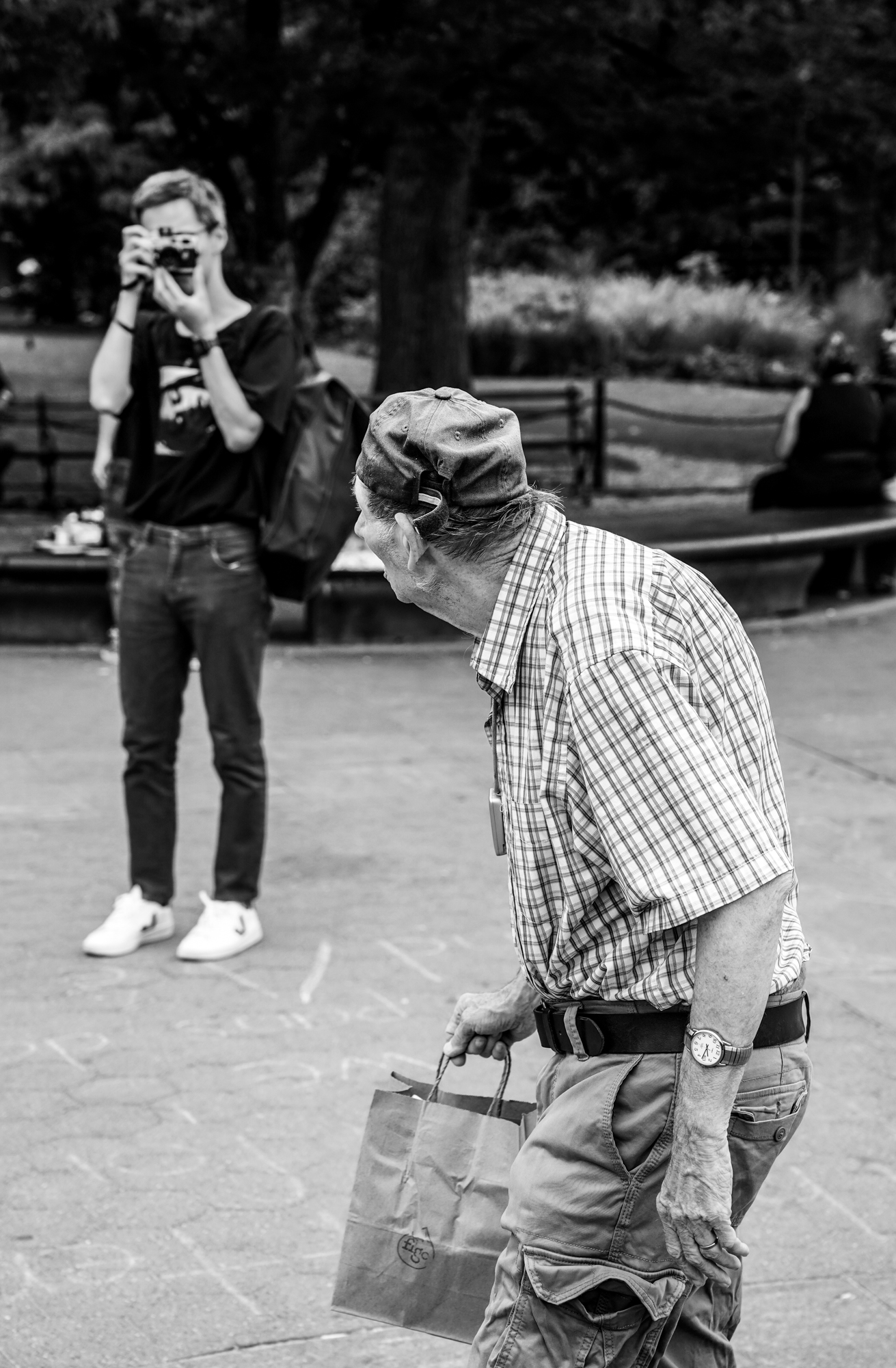 Two photographers shooting the same person, Washington Square Park, New York. Photographed by Rainer DeLalio