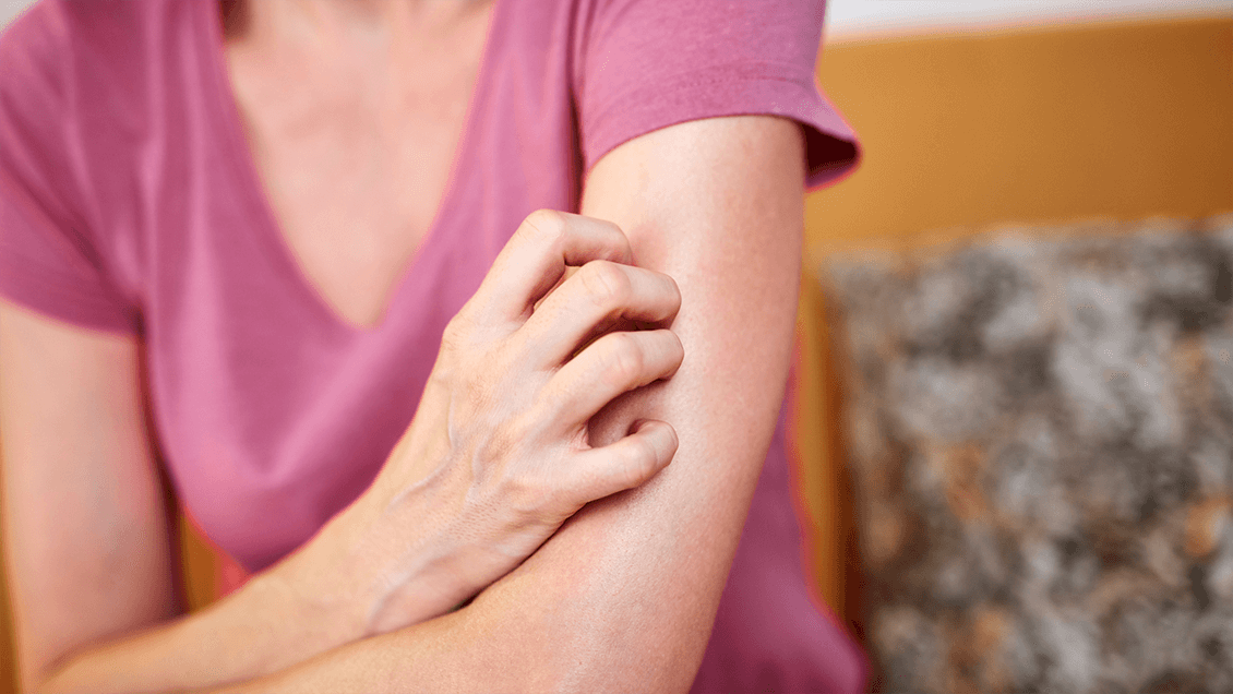 Person holding their arm, representing chronic pain from fibromyalgia