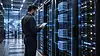 Technician monitoring server racks with virtual server overlays, illustrating VPS hosting.