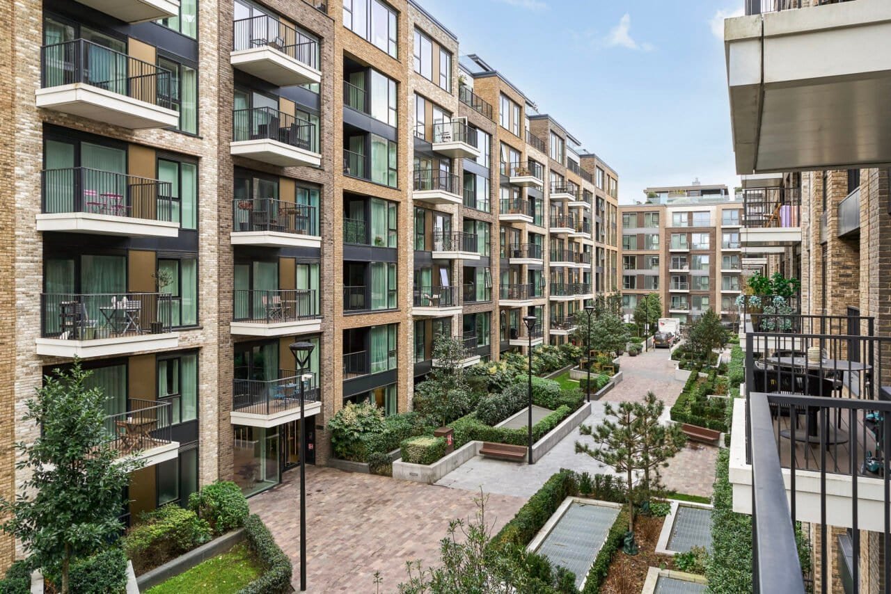 Modern residential apartment complex with landscaped gardens and balconies.