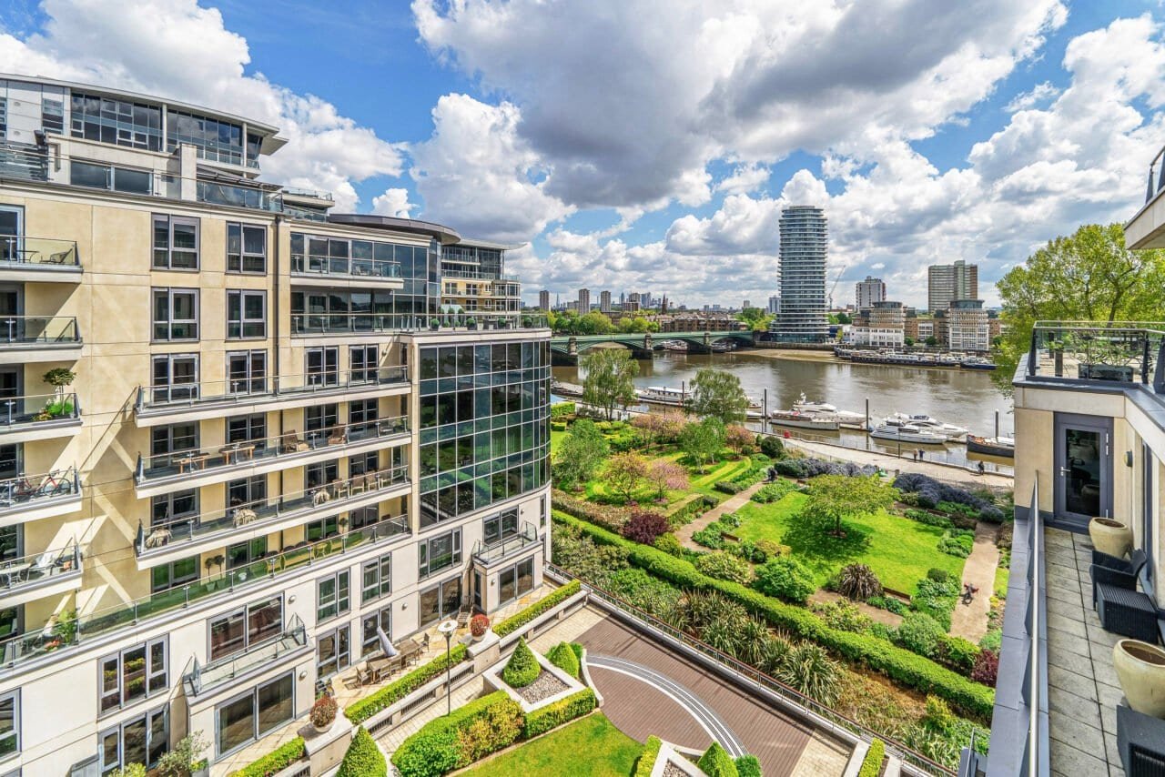 A modern riverside apartment with balcony and city views in London.