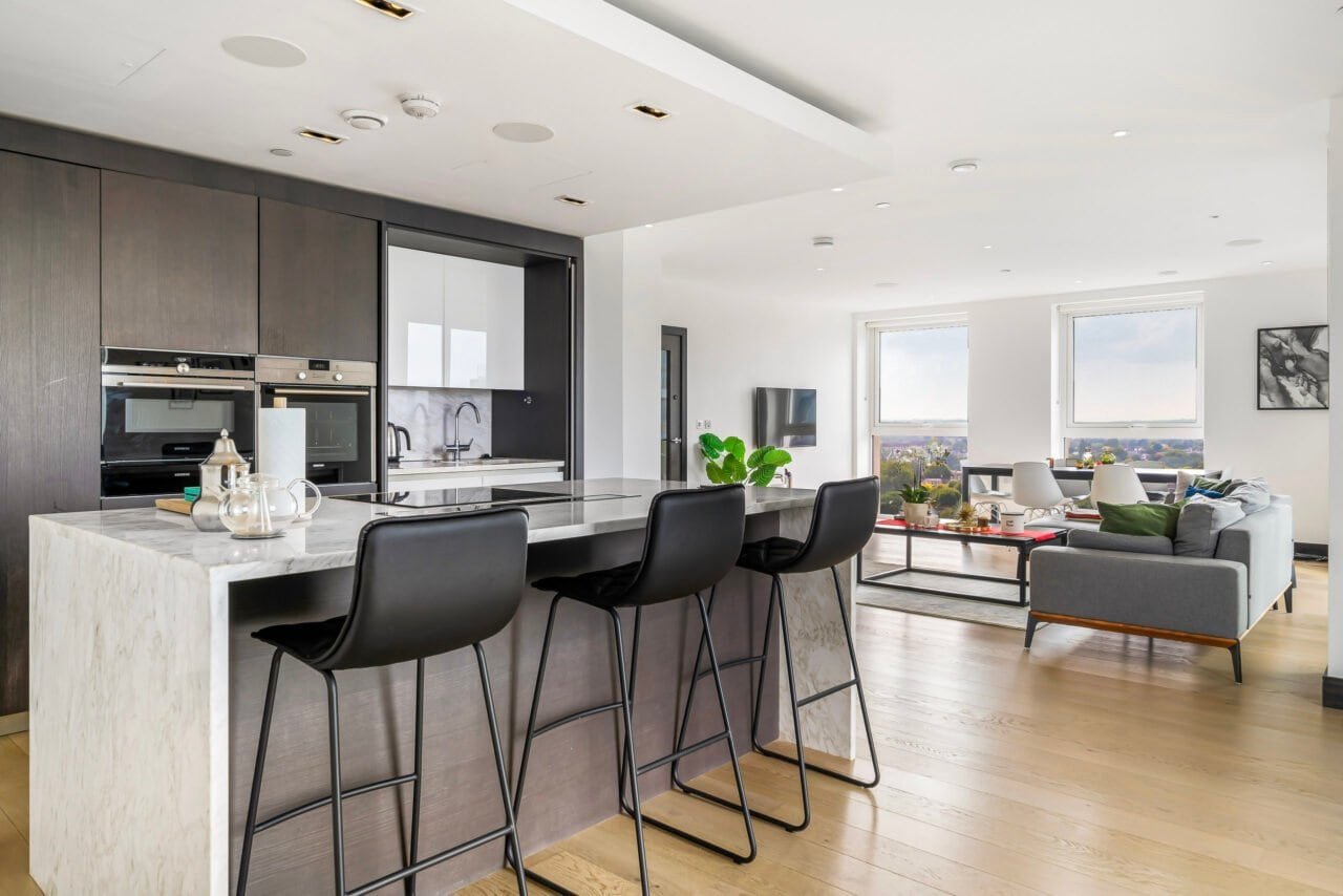 Modern open-plan kitchen and living room with large windows and contemporary furniture.