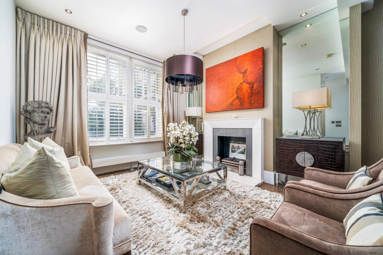 A cozy living room with modern decor, fireplace, and large windows for natural light.