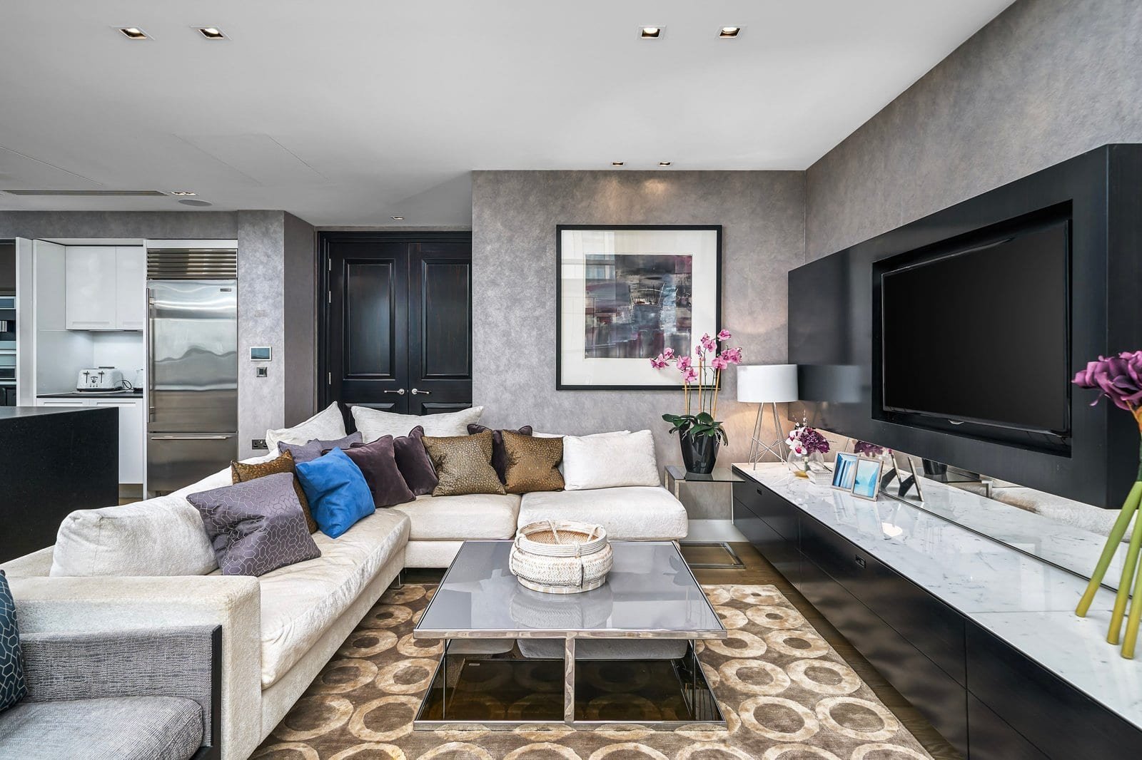 Modern living room with grey walls, large TV, and stylish decor, luxury interior design.