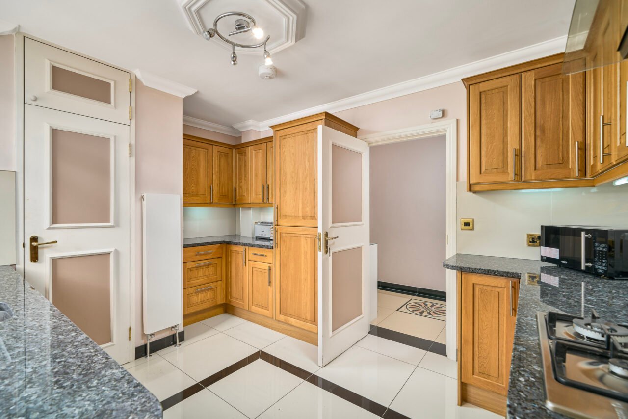 A modern kitchen with wooden cabinets and grey granite countertops.