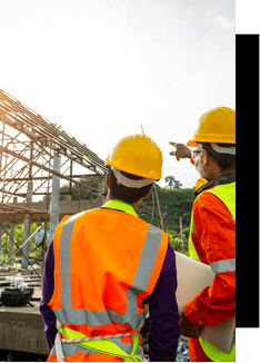 Site inspection at construction site with engineers in safety gear, focusing on industrial automation and project management solutions.