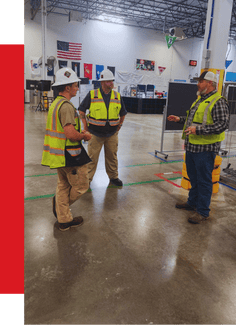 High-tech industrial automation specialists discussing system integration at a manufacturing expo, showcasing advanced digital solutions for optimized production processes.