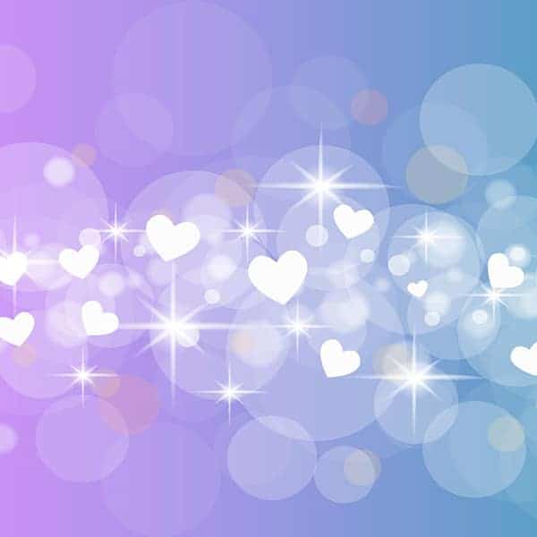 Abstract bokeh background with hearts and sparkles in pastel purple and blue tones.