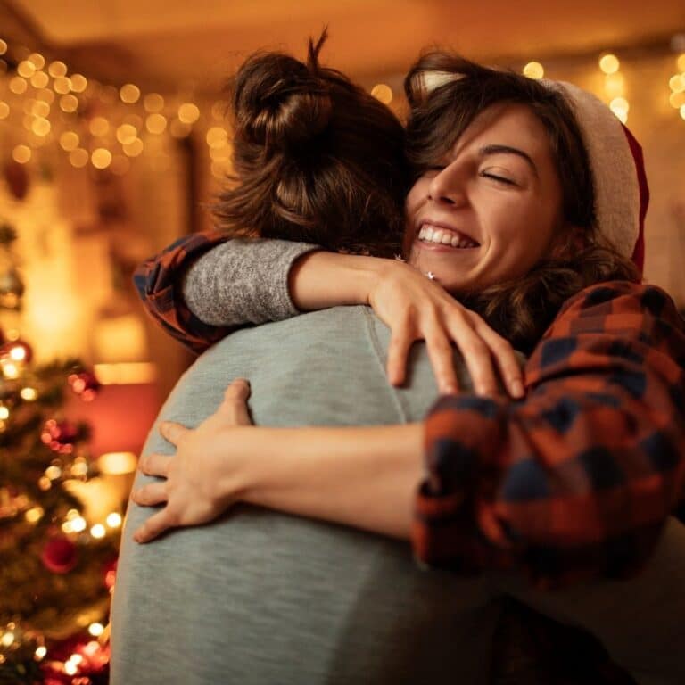 Hugging friends during festive season, capturing gratitude and connection.