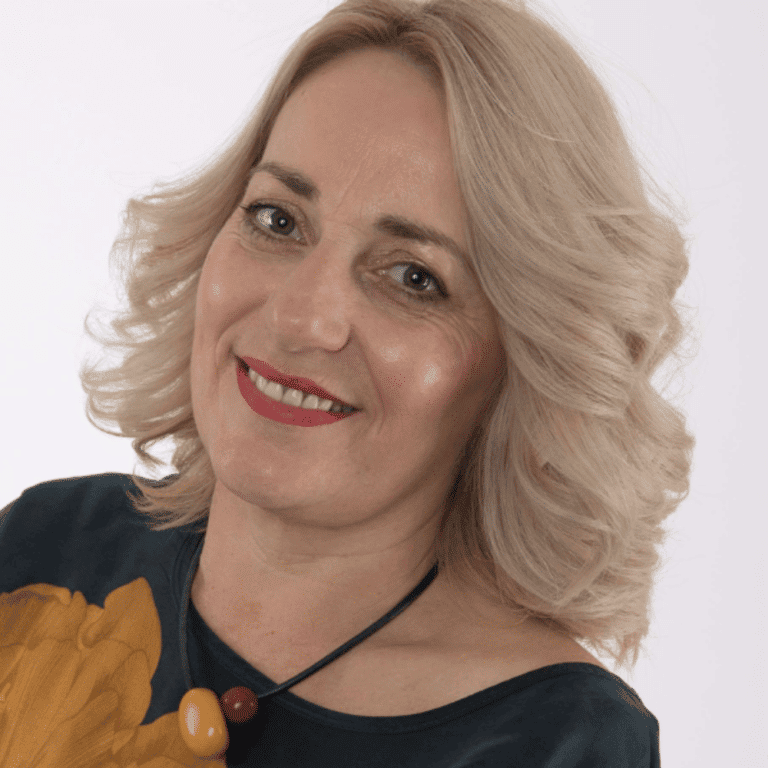 Woman smiling with blonde hair, professional headshot for Raw Horizons.