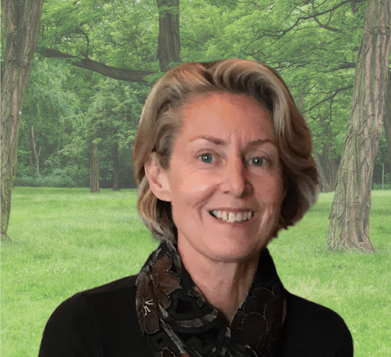 Portrait of Sally Bratton outdoors in a lush green forest setting.