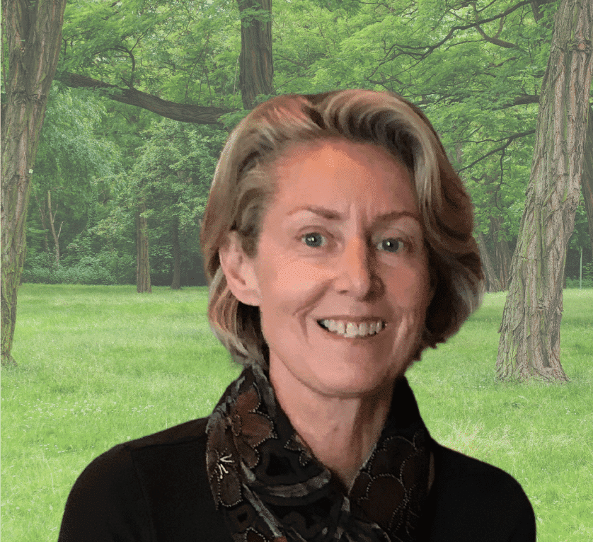 Portrait of Sally Bratton outdoors in a lush green forest setting.