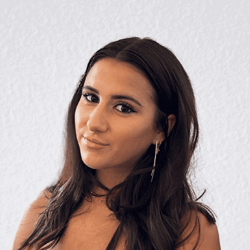 Woman with dark hair and earrings, looking confidently at the camera.