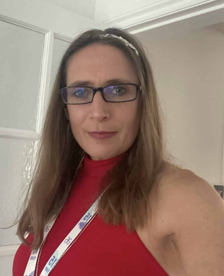 Woman with glasses and red top at professional event.