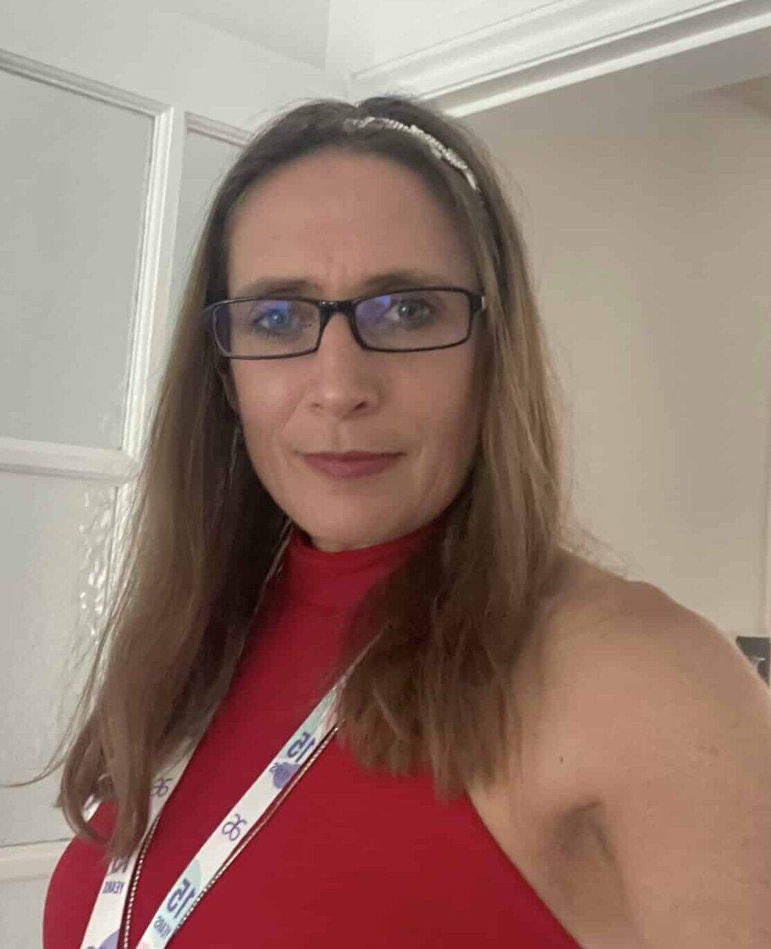 Woman with glasses and red top at professional event.