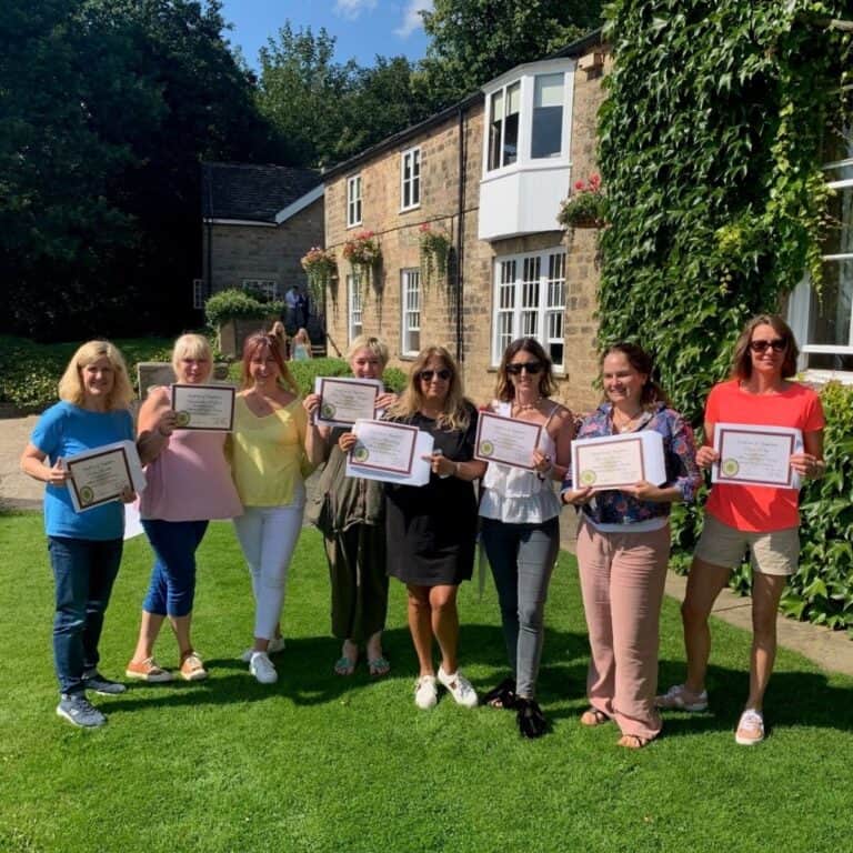 RH graduates with certificates after completing their Health and Wellbeing Coach Training