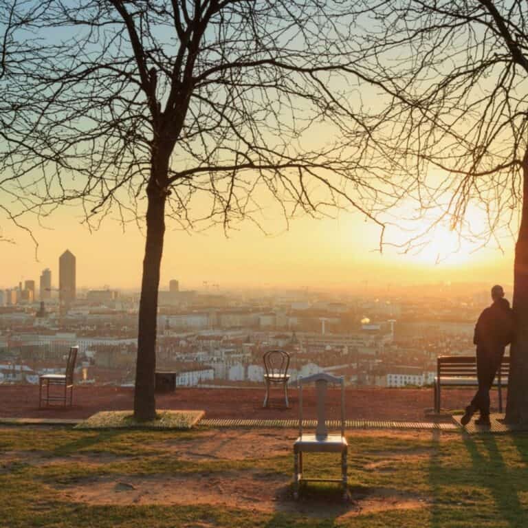 Empty chair overlooking a city at sunrise, representing new beginnings and possibility
