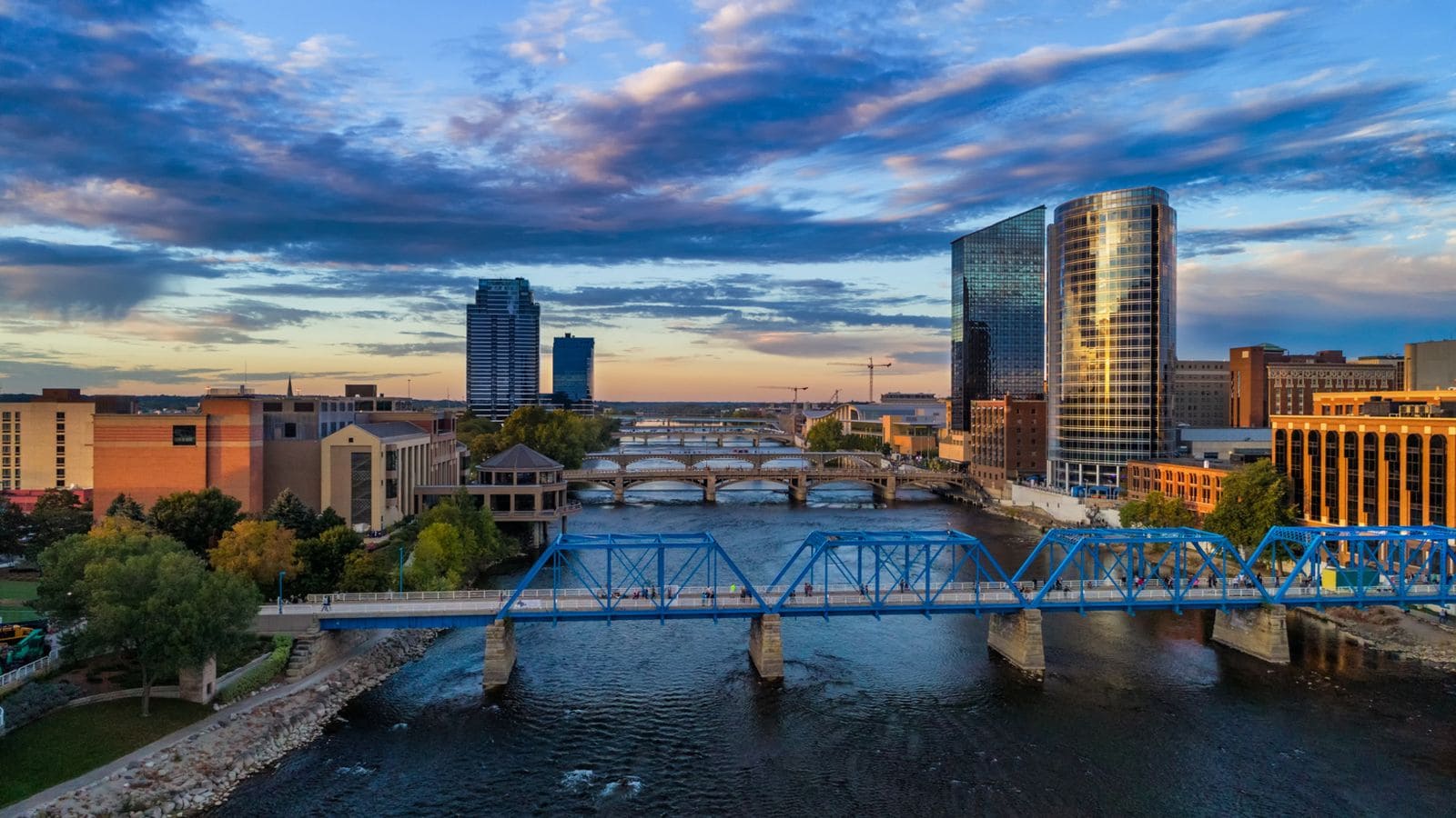 Vibrant cityscape featuring modern skyscrapers, bridges, and a flowing river at sunset, showcasing urban architecture and skyline views. Perfect for travel, city life, or skyline photography SEO keywords.
