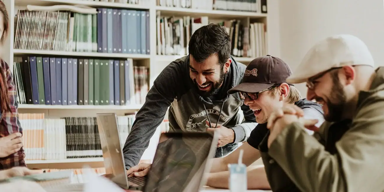 Group of designers collaborating on web project in a library setting.