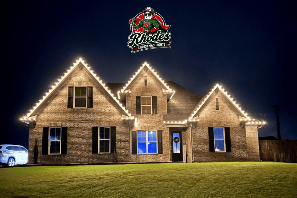 Brightly lit house with Christmas lights and Rhodes Christmas Lights logo.