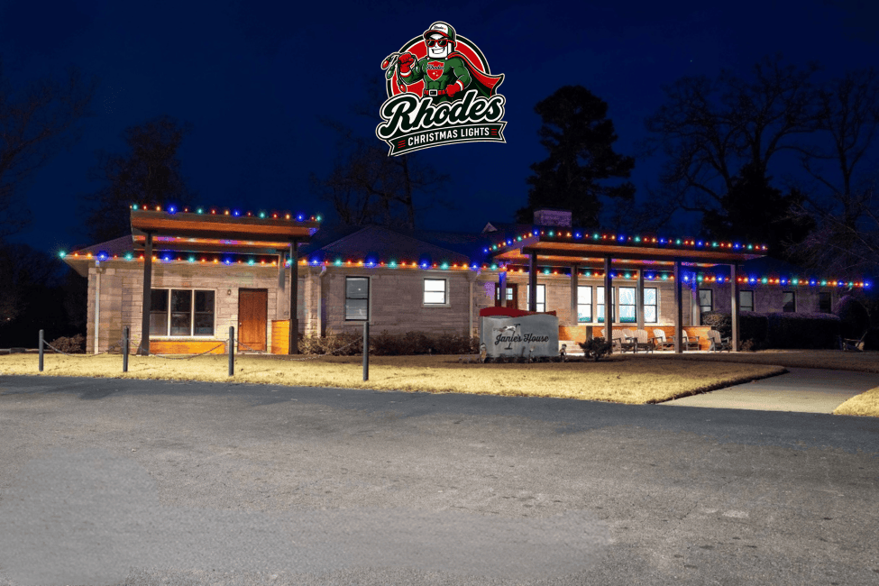 Colorful Christmas lights decorate the roof of Rhodes Christmas Lights building at night.