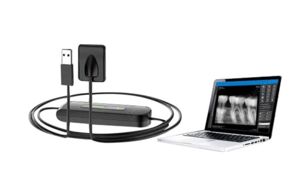 RIXI USB dental X-ray sensor with interface cable beside a laptop display