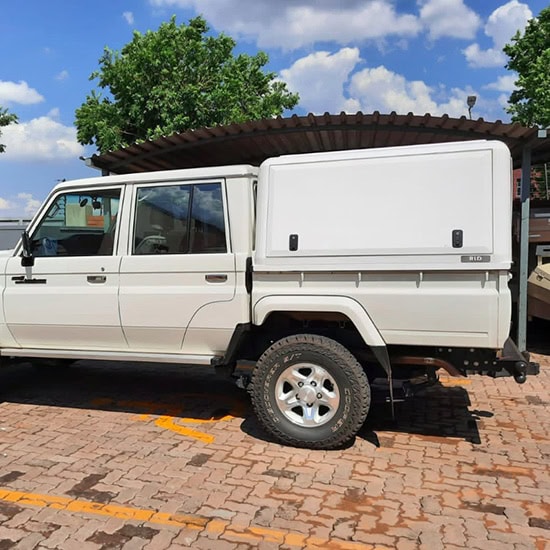Stainless steel canopy installed on a white utility truck, providing durable weather protection and increased cargo security for commercial use.