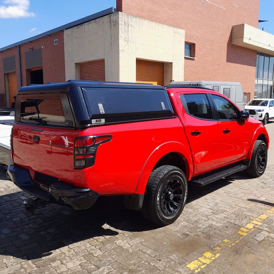 High-quality stainless steel canopy on a red pickup truck for durability and style.