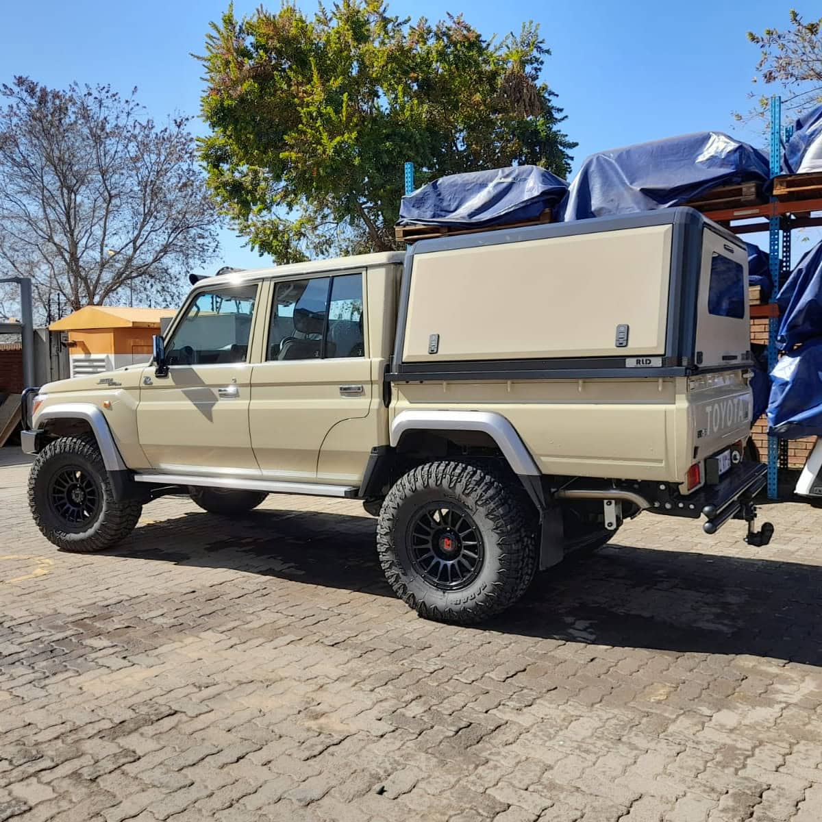 RLD Design stainless steel canopy installation on a beige off-road vehicle for durable outdoor protection, custom-made for rugged vehicle accessories and enhanced utility.