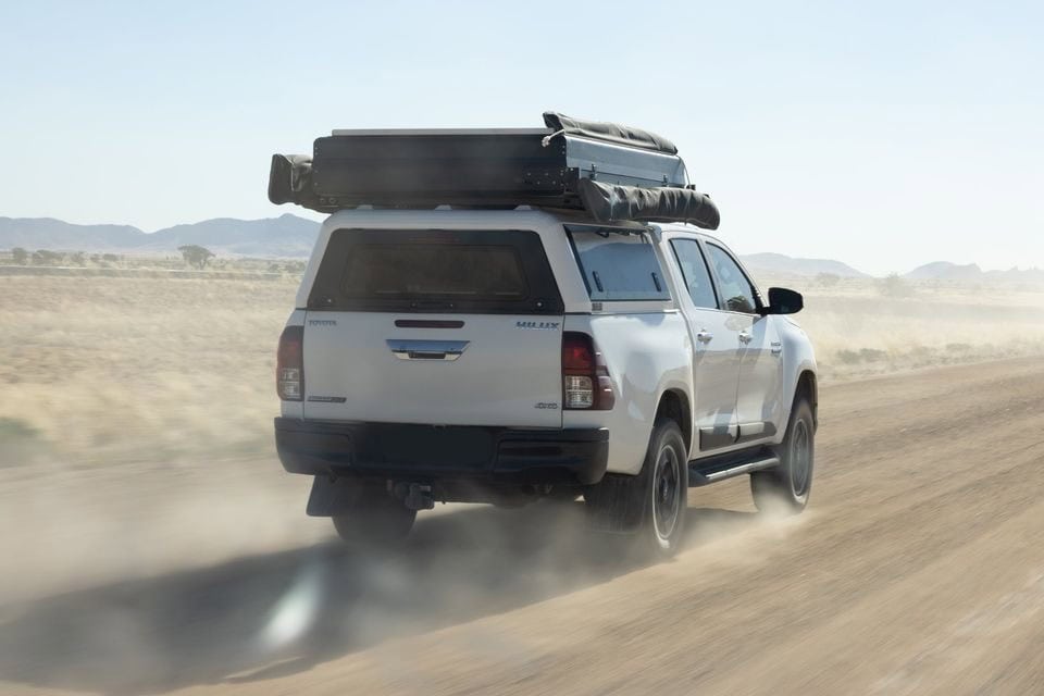 Aluminum stainless steel canopy installation on a rugged off-road vehicle in desert terrain.