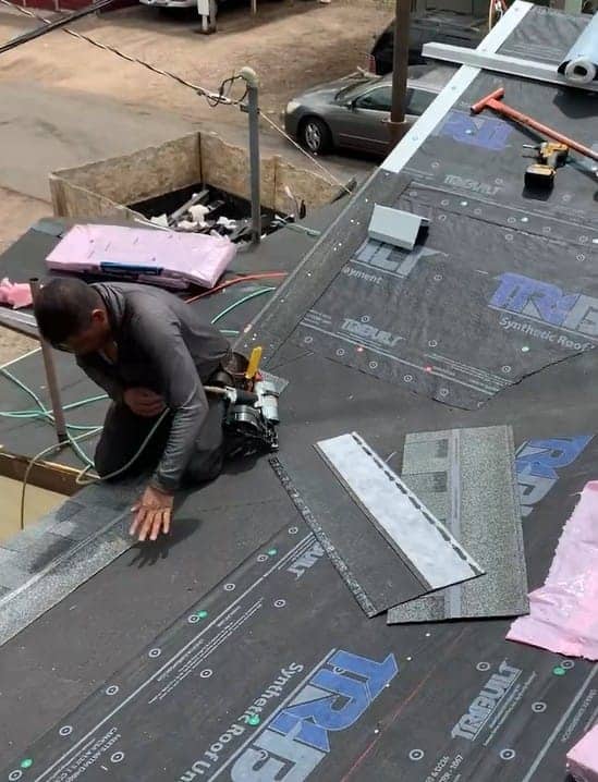 Roofing crew working on a residential roof in Denver, Colorado during a sunny day