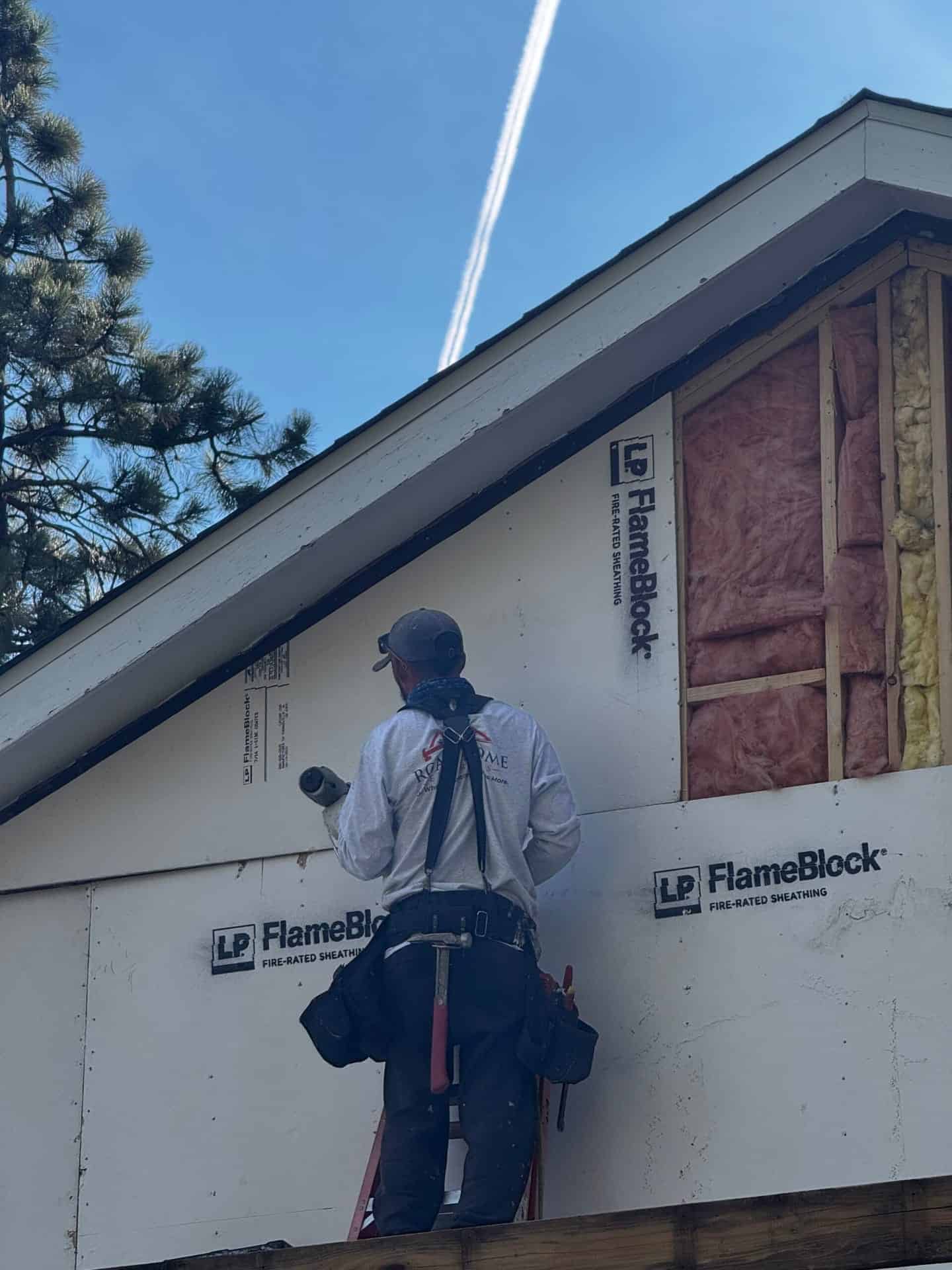 Road Home Exteriors crew member installing LP FlameBlock fire-rated OSB sheathing on a Colorado home