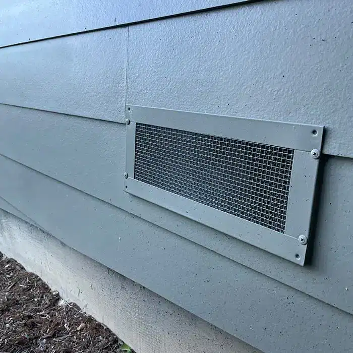 ember-resistant foundation vent installed in exterior siding wall for wildfire protection